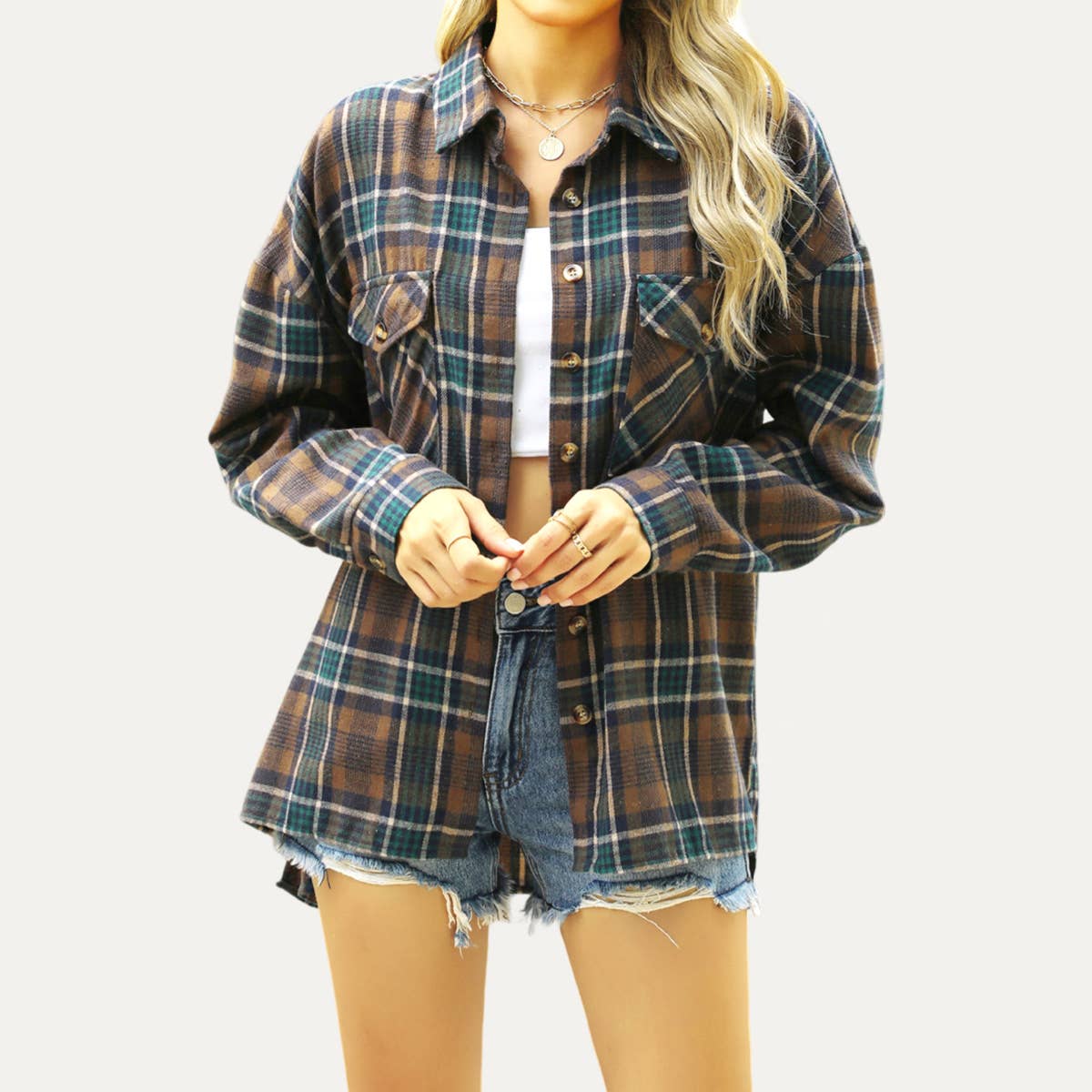 Person wearing a plaid shirt and denim shorts on a white background